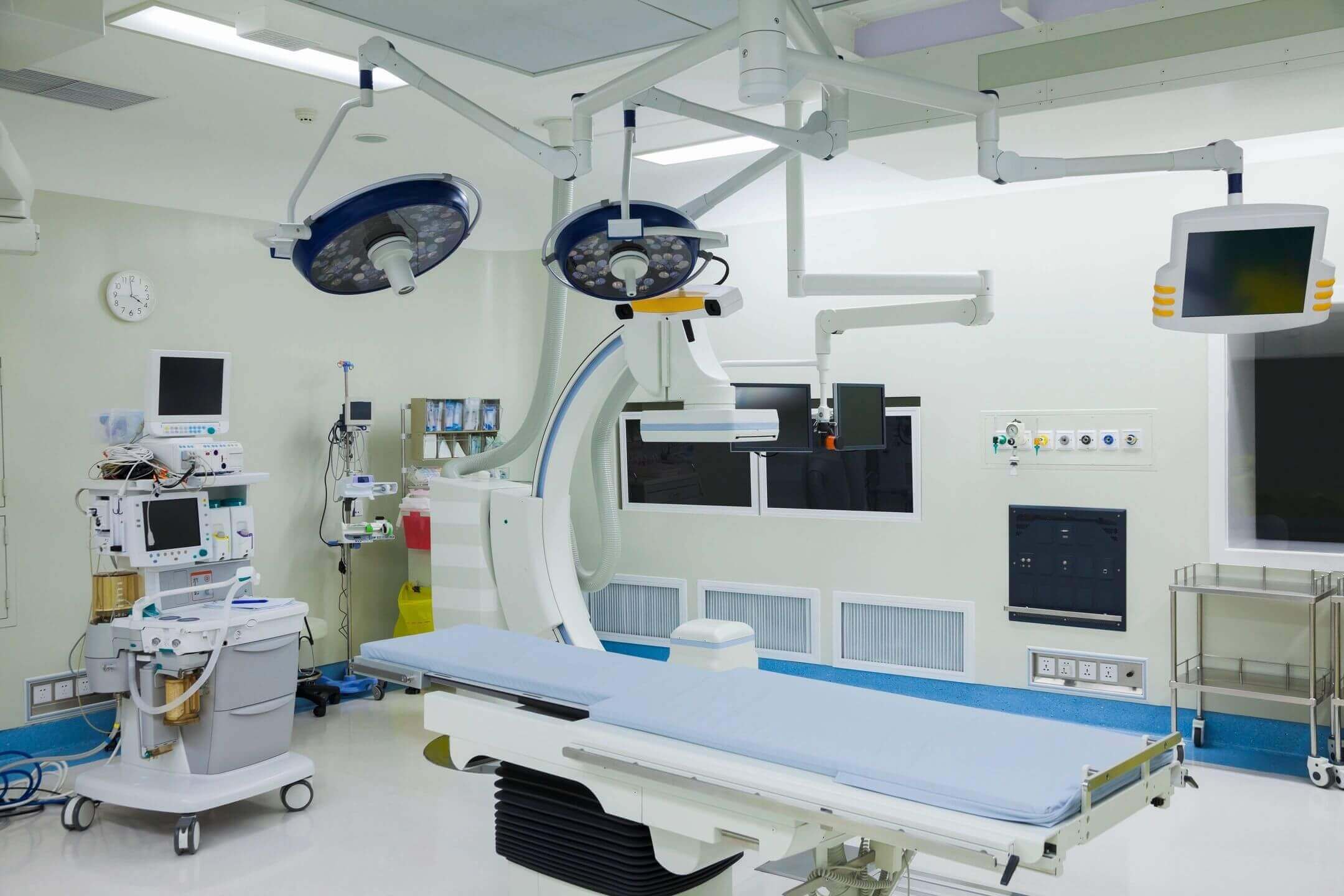Modern operating room with advanced medical equipment and surgical lights.