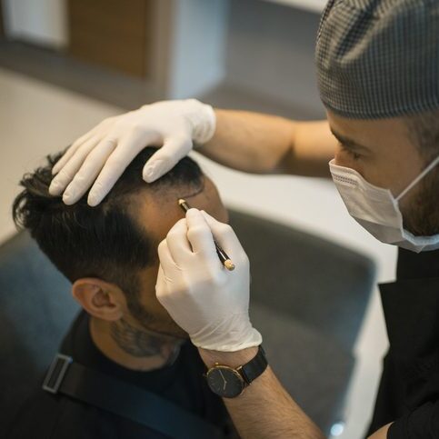 A professional performs a cosmetic procedure on a client's eyebrows.