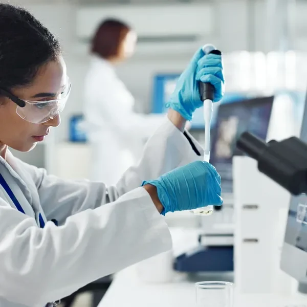 Scientist using a pipette in a laboratory.